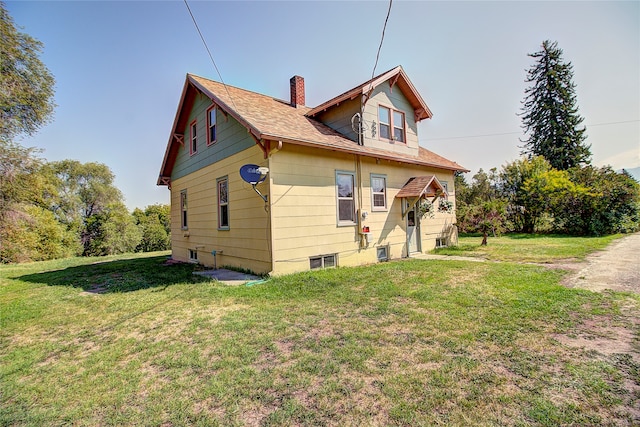 rear view of property with a lawn