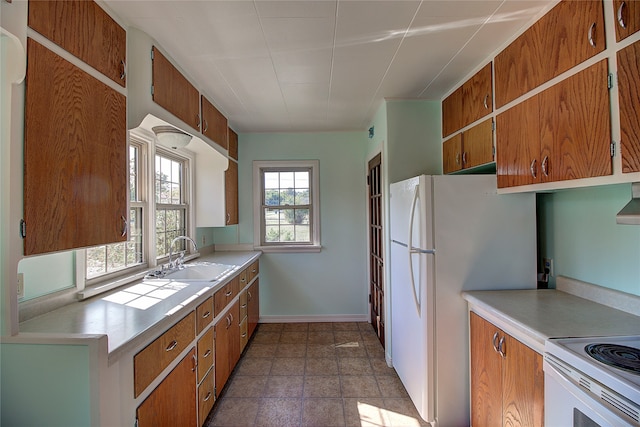 kitchen with white fridge, light tile patterned flooring, and sink