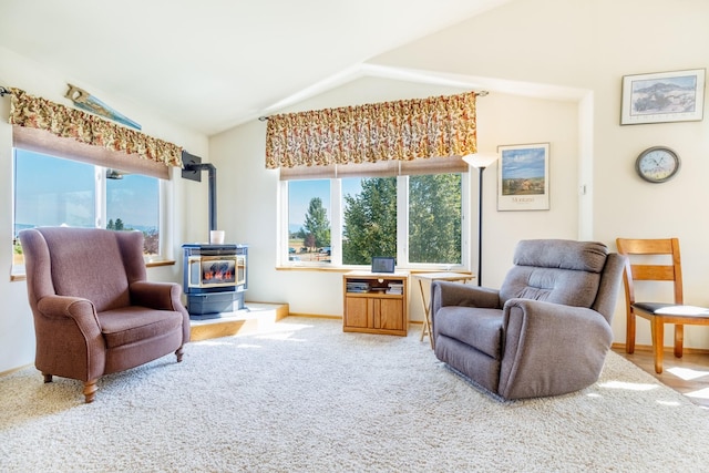 sitting room with baseboards, carpet, a wood stove, and vaulted ceiling