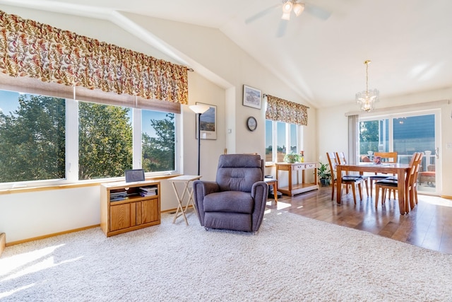 sitting room with vaulted ceiling, carpet flooring, ceiling fan with notable chandelier, and baseboards