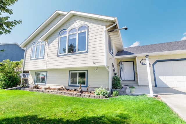 split level home featuring a garage, roof with shingles, and a front lawn