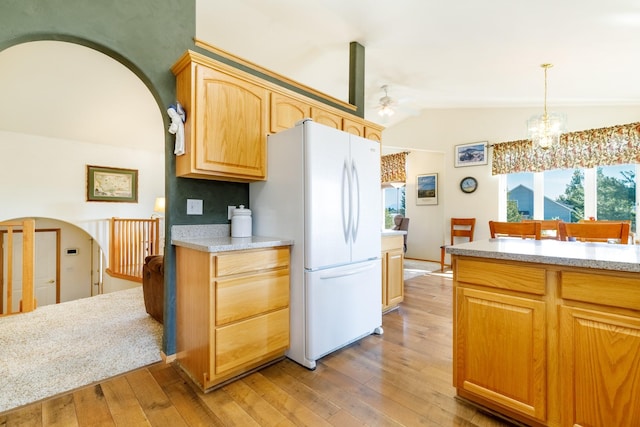 kitchen with light wood finished floors, light countertops, freestanding refrigerator, and lofted ceiling