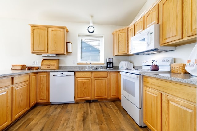 kitchen with a sink, light brown cabinets, light stone counters, white appliances, and wood-type flooring