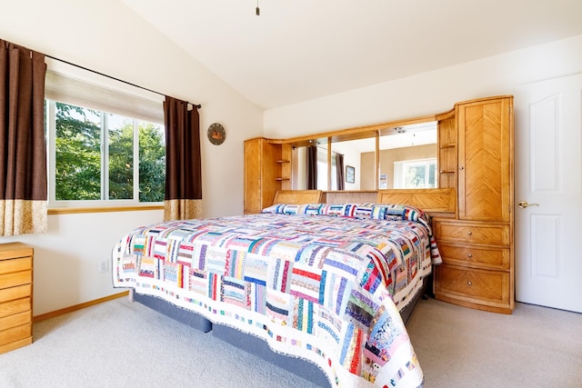 carpeted bedroom featuring baseboards and lofted ceiling