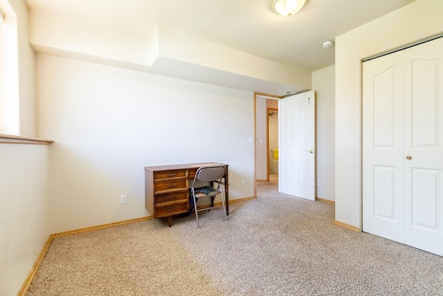 carpeted bedroom featuring a closet and baseboards