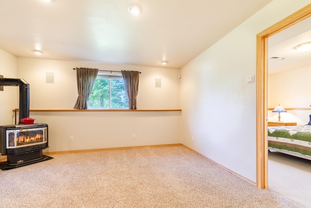 interior space featuring recessed lighting, baseboards, and a wood stove