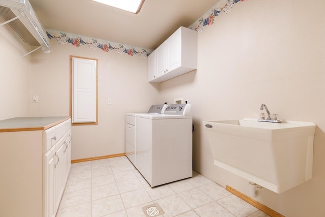 laundry area with a sink, baseboards, cabinet space, and independent washer and dryer