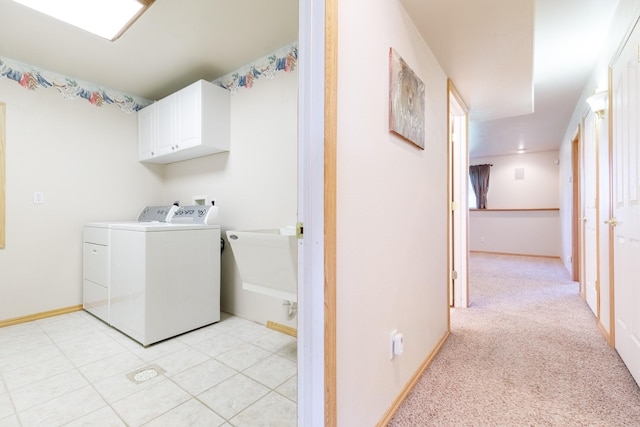 clothes washing area featuring baseboards, light colored carpet, cabinet space, independent washer and dryer, and a sink