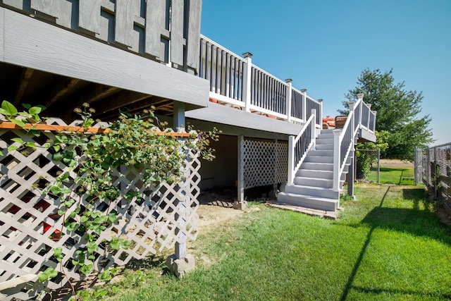 exterior space featuring a lawn, a deck, stairs, and fence