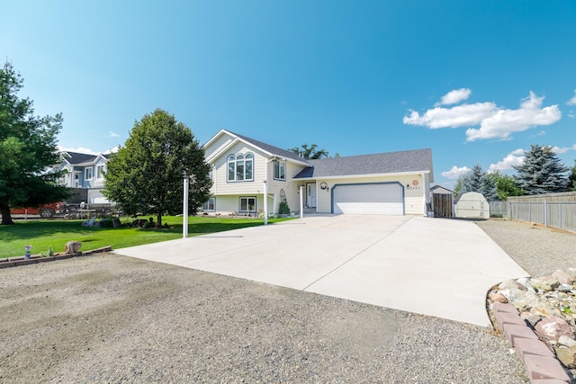 view of front facade featuring driveway, a gate, fence, a front yard, and an attached garage