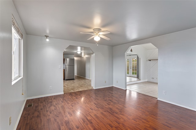 empty room featuring french doors, hardwood / wood-style flooring, and ceiling fan