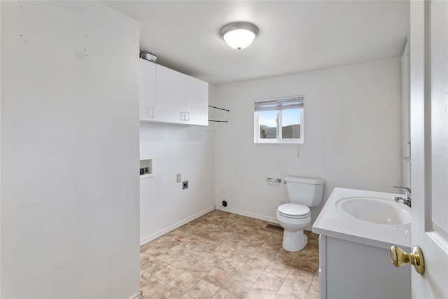 bathroom featuring toilet, baseboards, and vanity