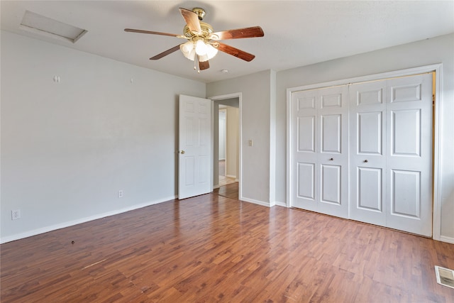 unfurnished bedroom featuring dark wood-type flooring, a closet, and ceiling fan