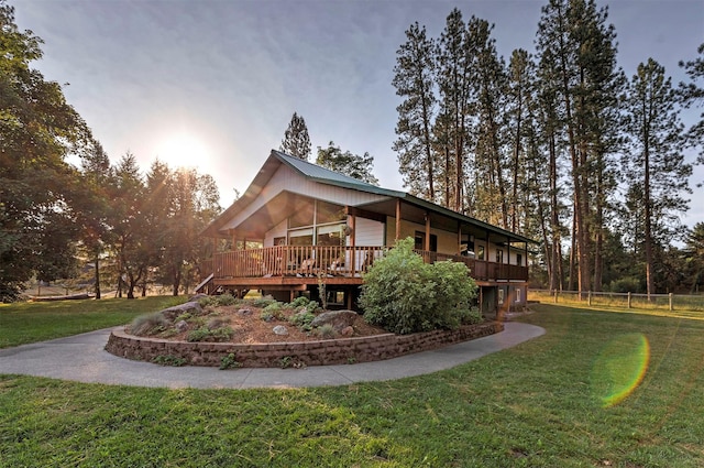 view of home's exterior with metal roof, a deck, and a yard