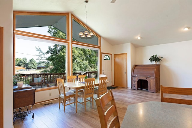 dining room featuring high vaulted ceiling, a healthy amount of sunlight, visible vents, and light wood finished floors