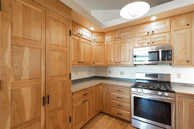 kitchen with appliances with stainless steel finishes, light wood-style flooring, and light brown cabinetry