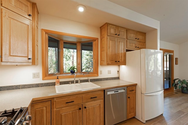 kitchen featuring recessed lighting, a sink, light wood-style floors, light countertops, and appliances with stainless steel finishes