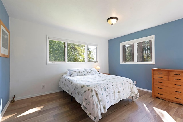 bedroom featuring wood finished floors and baseboards