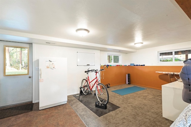 workout room with a wealth of natural light and baseboards