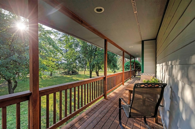 wooden terrace featuring a lawn