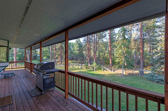 wooden deck with a lawn and area for grilling