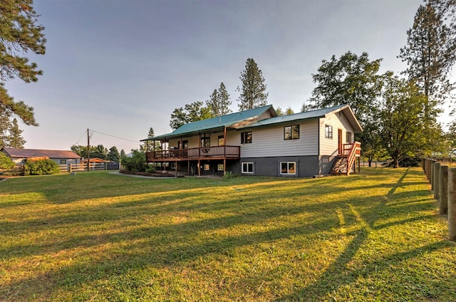 back of house featuring a wooden deck, stairs, fence, and a yard