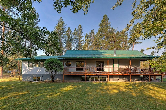 rear view of house with metal roof and a lawn