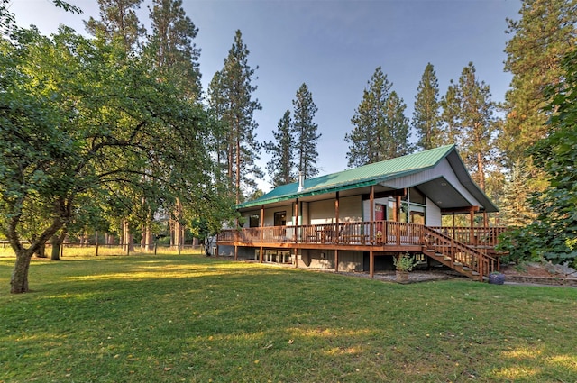 view of front of house with a deck, stairway, metal roof, and a front yard