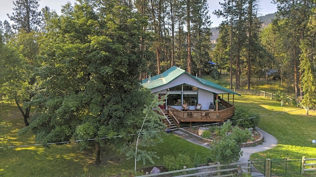 rear view of house with a fenced front yard, a lawn, and a wooden deck