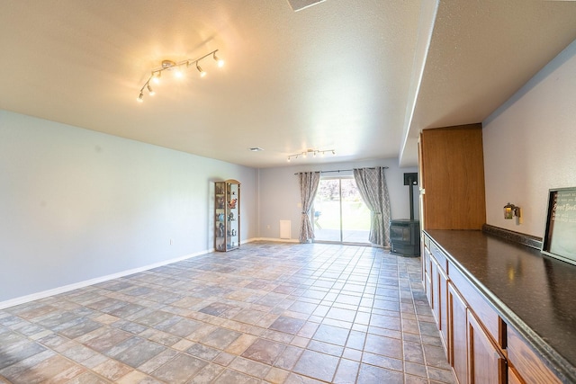 unfurnished living room featuring track lighting and a textured ceiling