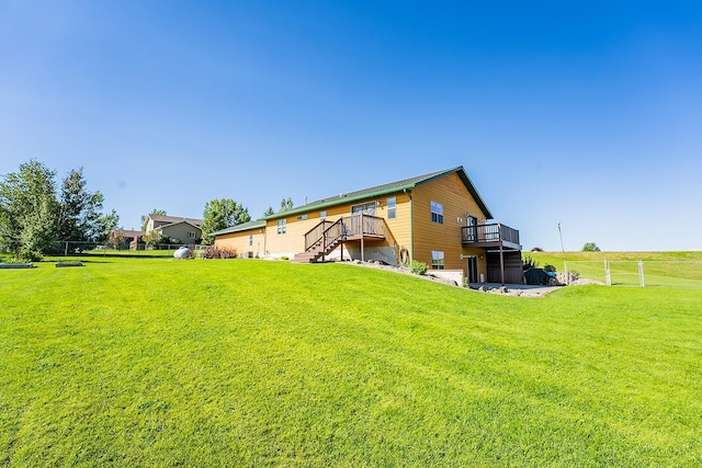 rear view of house with a deck and a yard