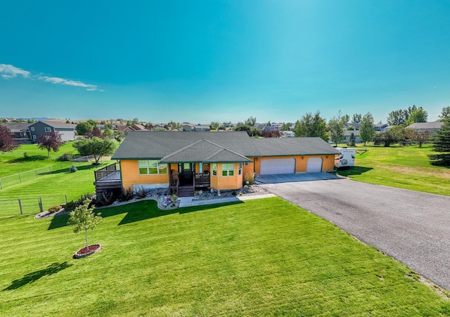 ranch-style home with covered porch, a front yard, and a garage