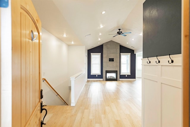 hall with light wood-type flooring and vaulted ceiling