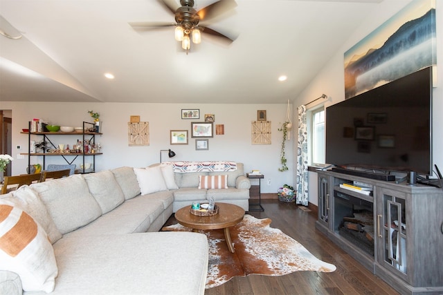 living room featuring dark hardwood / wood-style flooring, vaulted ceiling, and ceiling fan