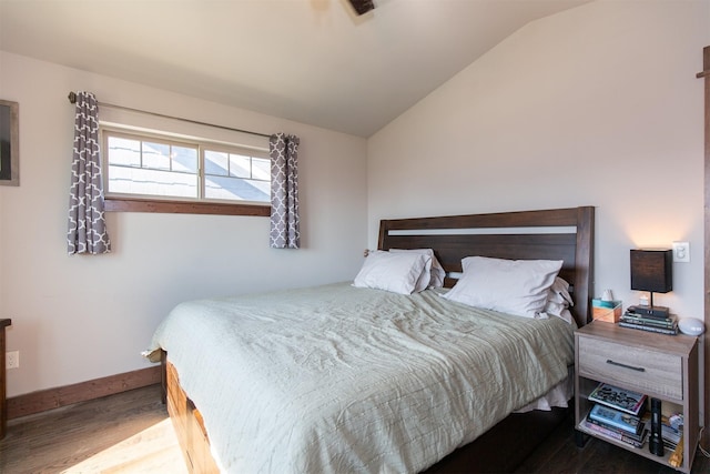 bedroom with hardwood / wood-style floors and lofted ceiling