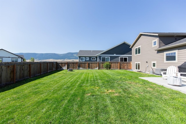 view of yard with a mountain view, central AC, and a patio