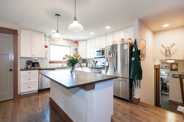 kitchen featuring appliances with stainless steel finishes, white cabinets, dark hardwood / wood-style floors, and backsplash