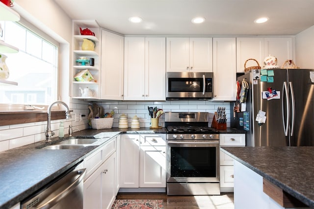 kitchen featuring white cabinetry, appliances with stainless steel finishes, sink, and backsplash