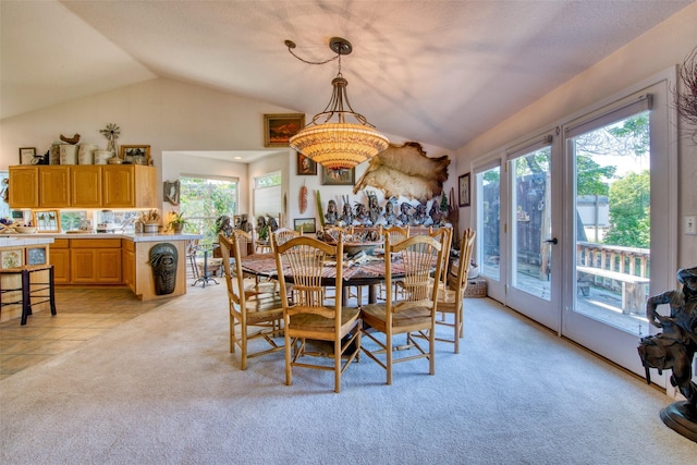 dining room with light tile patterned floors, light colored carpet, and lofted ceiling