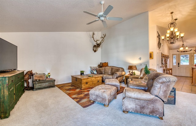 living area with ceiling fan with notable chandelier, carpet, high vaulted ceiling, and a textured ceiling