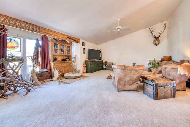 living area with a textured ceiling, carpet, a ceiling fan, and vaulted ceiling