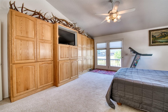 bedroom with a ceiling fan, lofted ceiling, light carpet, a textured ceiling, and access to outside