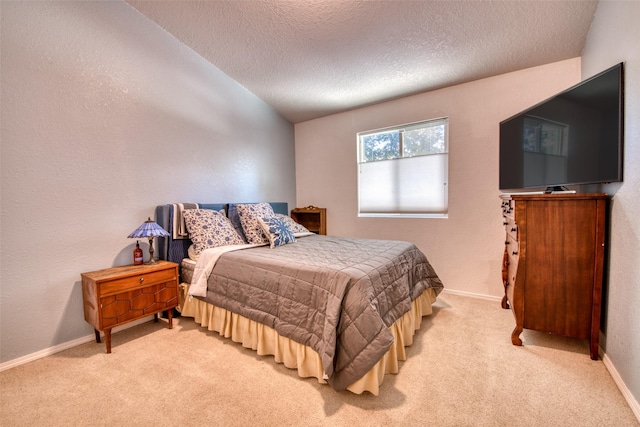 bedroom with baseboards, light carpet, a textured ceiling, and a textured wall