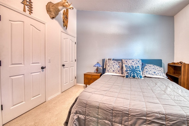 carpeted bedroom featuring a textured ceiling and baseboards