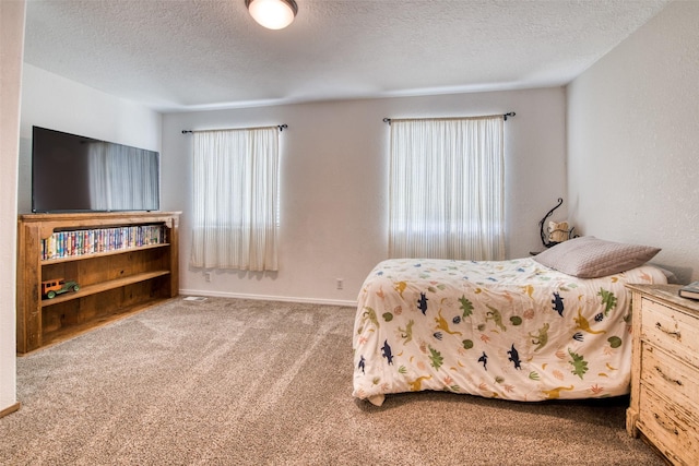 bedroom with baseboards, carpet, and a textured ceiling