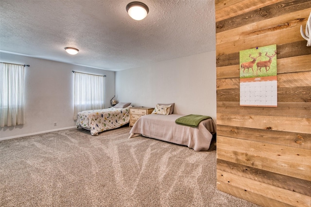 carpeted bedroom with a textured ceiling and wooden walls