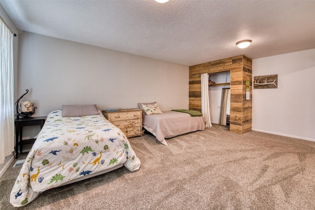 bedroom featuring visible vents, baseboards, carpet floors, a closet, and a textured ceiling