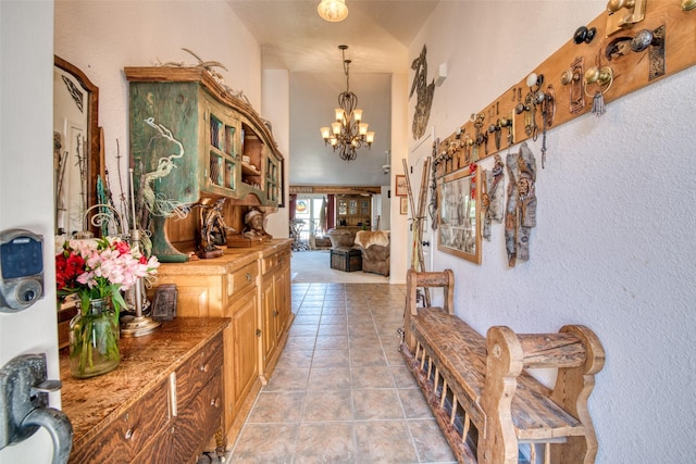 hallway featuring light tile patterned floors and an inviting chandelier