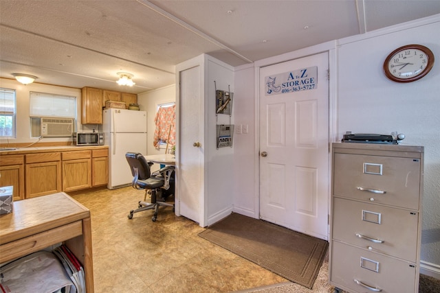 kitchen with stainless steel microwave, freestanding refrigerator, cooling unit, light countertops, and light floors