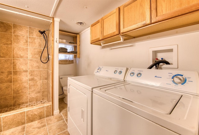 laundry area featuring cabinet space, light tile patterned flooring, separate washer and dryer, and visible vents